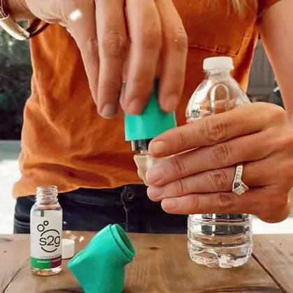 Pressing the cap onto a water bottle